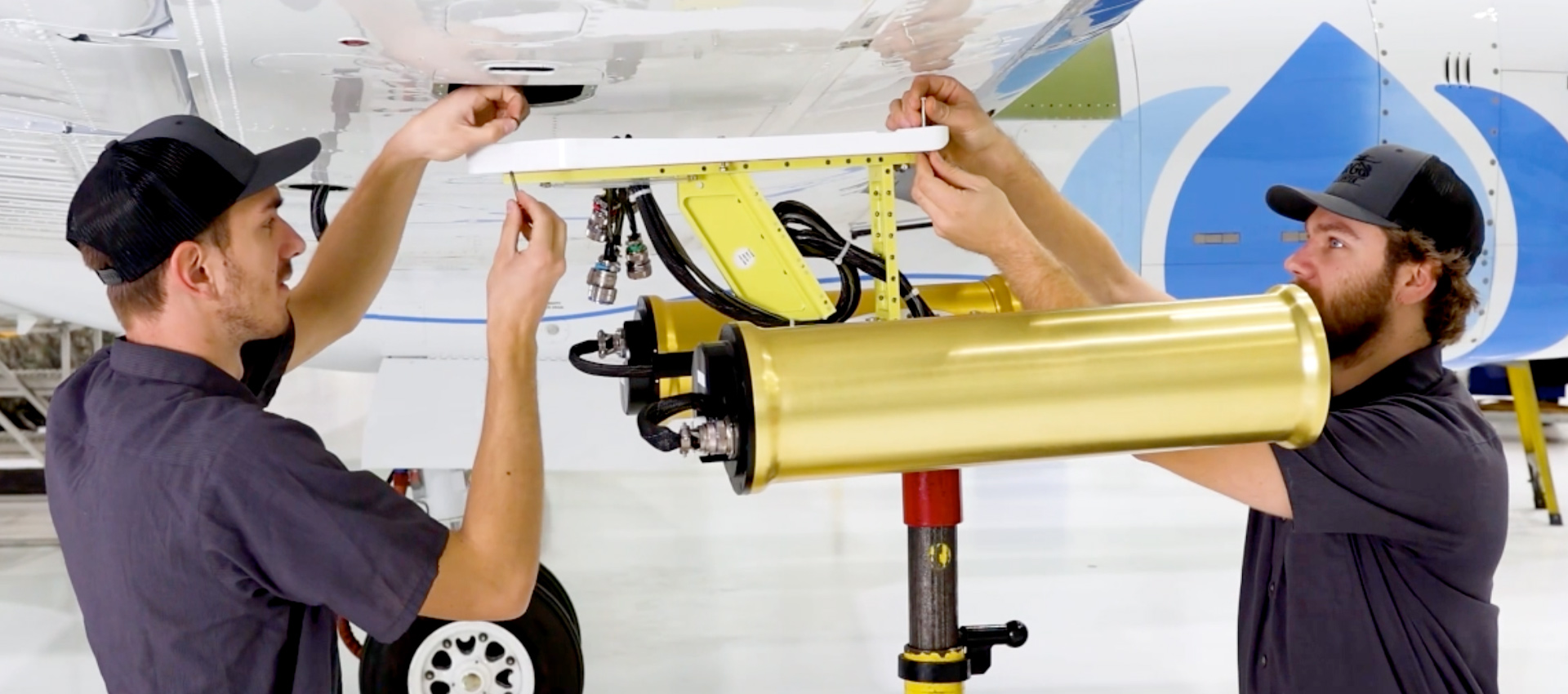 Two SPEC Inc technicians install atmospheric research instruments on an aircraft